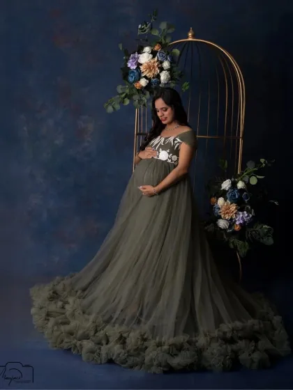 A different gown, a different mood. This olive green dress provides a beautiful, earthy contrast to the dark blue backdrop and cage prop, creating a rich, elegant portrait.