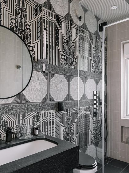 A detail of the black and white bathroom at Eden House, featuring custom wall lights and intricately patterned tiles that feel like a warm hug for the soul.