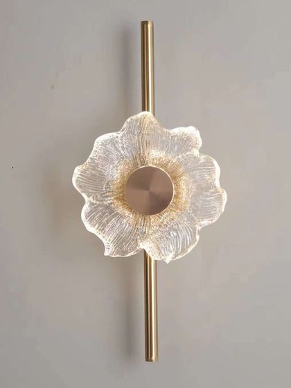 A close-up of the flower-shaped glass wall light. The intricate details of the glass create a beautiful, delicate effect.