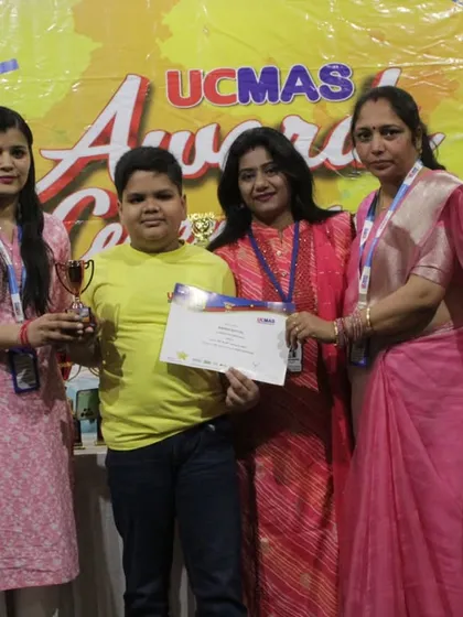 A student receives his award at the National Level Competition (NLC) Awards Ceremony. This moment highlights the strong support system between our students, parents, and instructors.