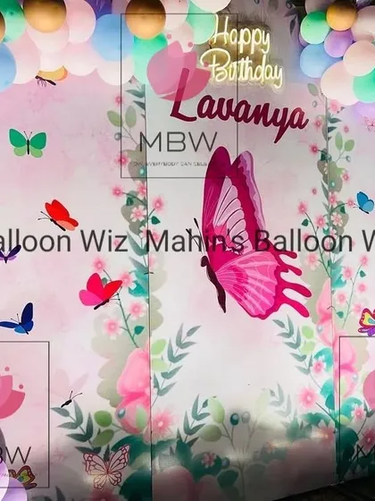 The butterfly backdrop illuminated at dusk, with the neon sign creating a magical and festive ambiance.