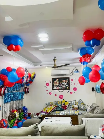 A full room view of the superhero themed home decoration. I use hanging balloons and wall decor to create an immersive party environment, even in a living room space.