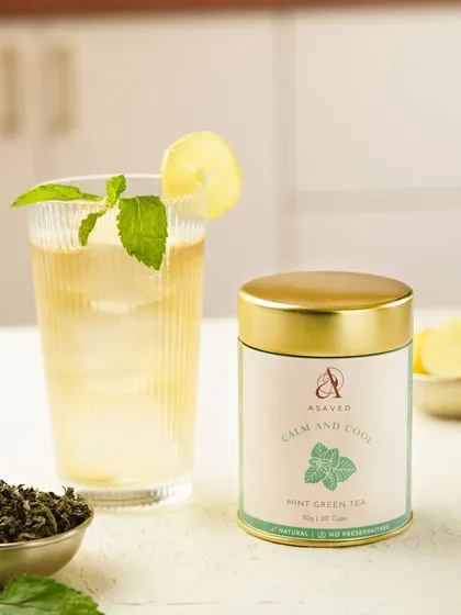 A crisp, clean shot of a mint green tea cooler, garnished with a lemon slice and fresh mint. The bright lighting makes it look incredibly refreshing.