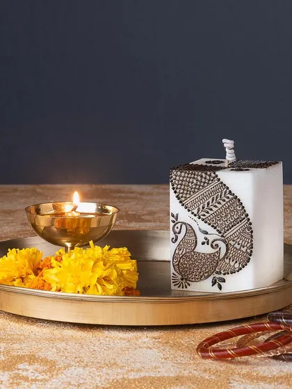 This square pillar candle is decorated with a beautiful peacock mehendi design, perfect for adding a touch of Indian artistry to your home.