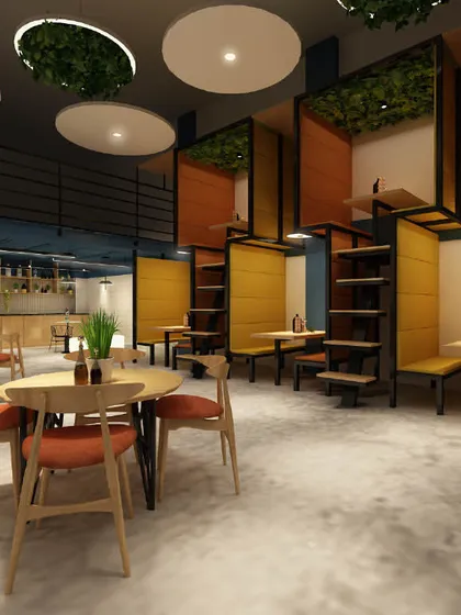 This office cafeteria features unique pod-style seating for small groups, with greenery hanging from the ceiling. The design prioritizes comfort and offers a variety of seating options.
