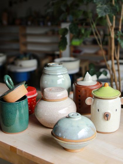 An assortment of lidded jars created during the professional course. Each piece, from the bear shaped jar to the crackle glaze pot, reflects the unique personality and skill of its maker.