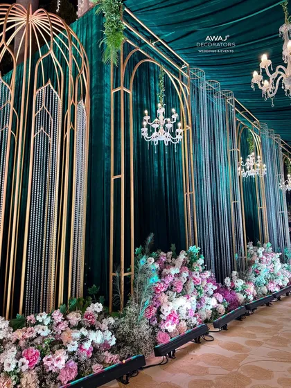 Another angle of the walkway, highlighting the elegant chandeliers and the rich texture of the emerald green drapes.