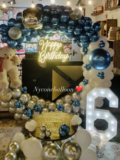 This 6th birthday decoration features a cool blue, silver, and white color scheme. I used a balloon ring, a light-up number '6', and a teddy bear to create a charming and celebratory setup.