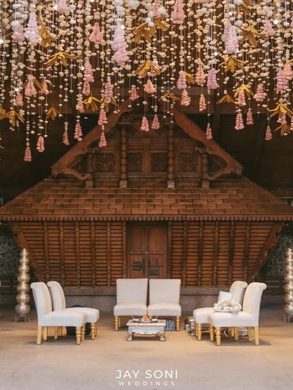 A closer view of the mandap seating, where the simplicity of the furniture allows the dramatic floral ceiling installation to take center stage. The design balances grandeur with an intimate, personal feel.