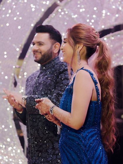 A candid shot of the couple enjoying their engagement ceremony. Their happy expressions and the festive background capture the joyful spirit of the event.