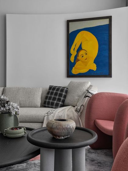 In this home, every wall is a canvas. This shot shows how carefully selected furniture, like the sculptural coffee table and textured vases, complements the bold artwork without competing with it, creating a harmonious and artistic composition.