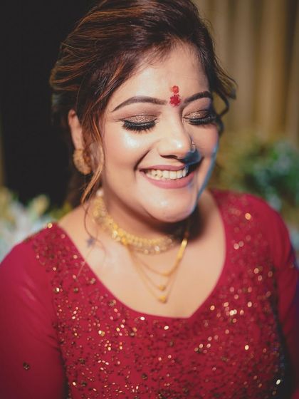 A joyful, candid shot of Ishita, her smile lighting up the frame. The shimmery eye makeup catches the light beautifully.