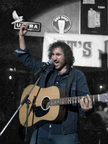 A powerful shot of our guitarist and vocalist, Jas, leading the crowd in a sing-along. His passion for music shines through in every performance.