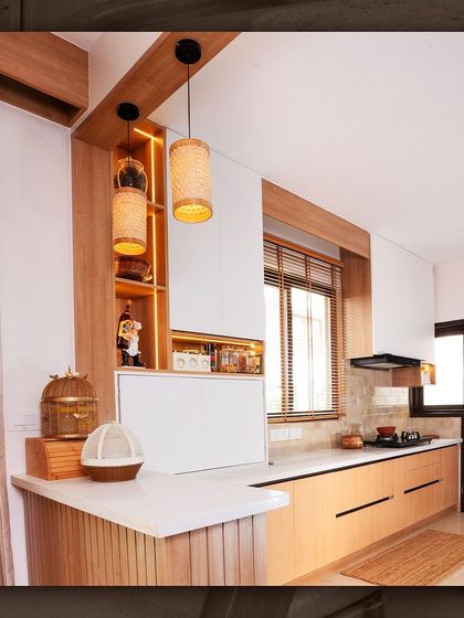 The kitchen and breakfast counter in the Japandi villa, designed with light wood tones and integrated shelving for a seamless and functional space.