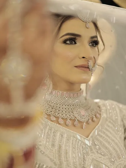 This angle captures the bride's beautiful features, enhanced by subtle contouring and a soft, defined eye. The diamond nose ring and jewellery pair perfectly with the cool-toned makeup.