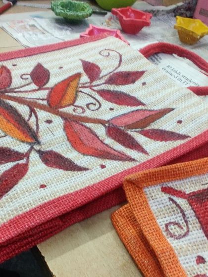 A close up of a beautifully painted bag with an autumn leaves design.