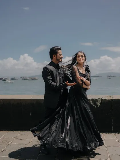 The wind catching her hair and dress by the Mumbai sea creates a beautiful sense of movement. This candid, joyful moment looks like a still from a romantic film.