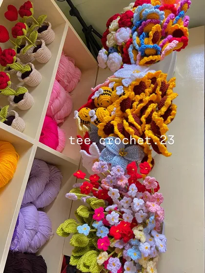 An artistic overhead shot of a diverse collection of crochet flowers and keychains, ready to be sorted and packed.