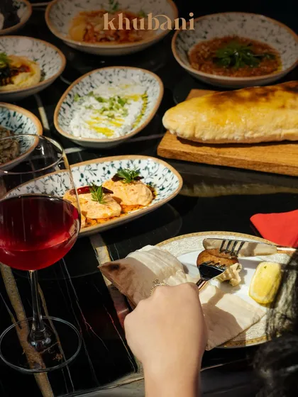Savor every bite, sip, and moment. A table laden with Turkish mezzes, fresh pita, and wine is where artistry meets fine dining.