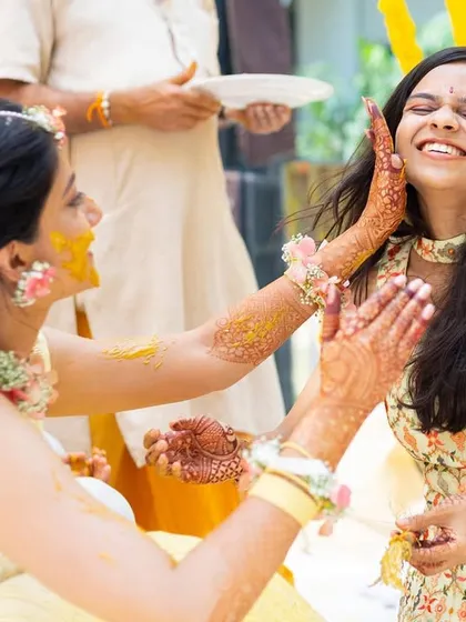 The Haldi ceremony is all about unrestrained joy, and we love being in the middle of it. This shot captures the playful, candid fun between a bride and her loved ones, a memory filled with laughter and color.