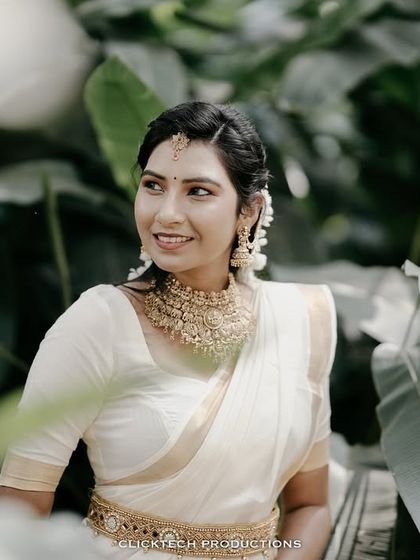 A lovely portrait of the bride-to-be, framed by large green leaves, creating a natural and beautiful composition.