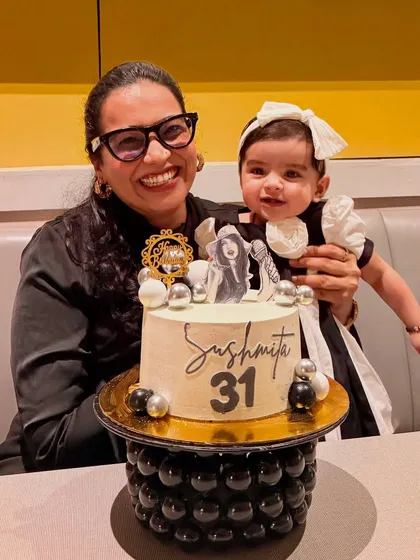 A lovely portrait of me and Gauri with my birthday cake. We are both looking at the camera, creating a perfect picture to remember the special day.