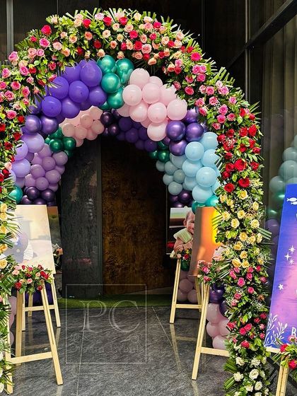 A beautiful welcome sign and floral balloon arch at the entrance to Vani's first birthday party. This setup ensures that the magical mermaid theme begins the moment guests arrive.