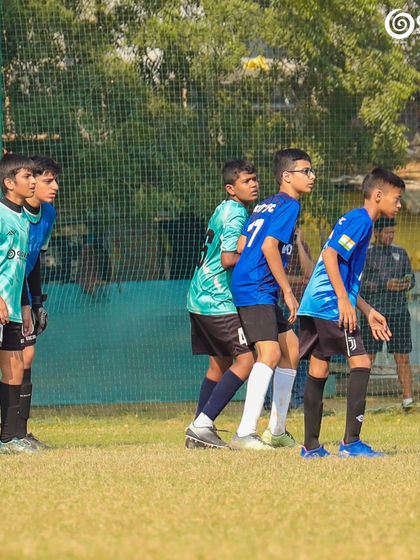 Players form a defensive wall, preparing to block a free-kick in a tense moment of the match.
