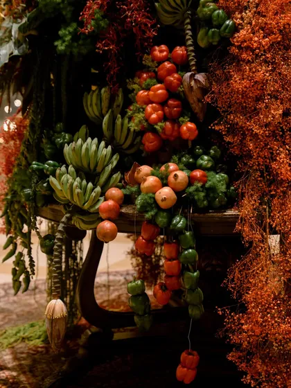 The magic is always in the details. Here, a closer look at a lobby installation reveals my love for unconventional textures. I paired fiery pomegranates, clusters of green bananas, and strings of peppers with rich red florals to create a composition that is both a visual and sensory feast, challenging the traditional definition of a floral arrangement.