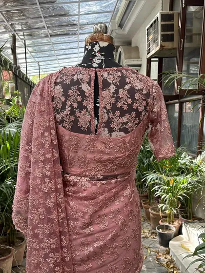 The back of the saree blouse features a keyhole design, adding an element of surprise and elegance.