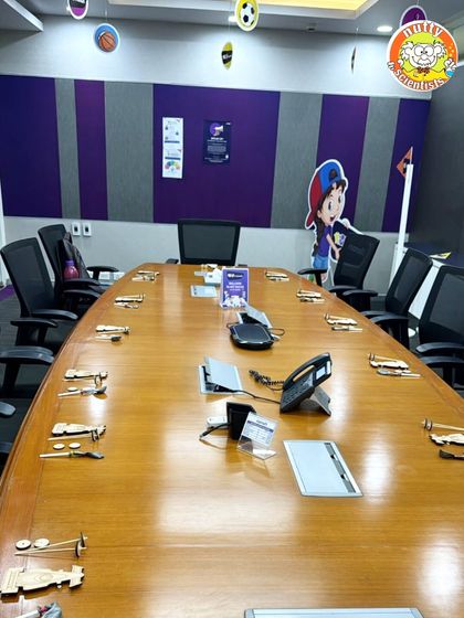 Another corporate event setup, this time for a model-building activity. Each seat at the conference table is set with a wooden vehicle kit, ready for kids to assemble and learn about engineering.