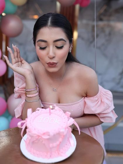 A wish being made over the single candle on the 100k celebration bento cake.