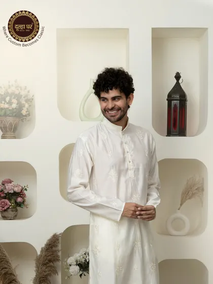 Elegance stitched to perfection. A smiling model in a classic white embroidered kurta, a picture of effortless charm.