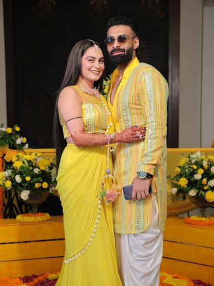 A classic posed portrait of the couple in their matching yellow Haldi outfits. This shot provides a timeless keepsake, capturing them looking their best during the pre wedding festivities.