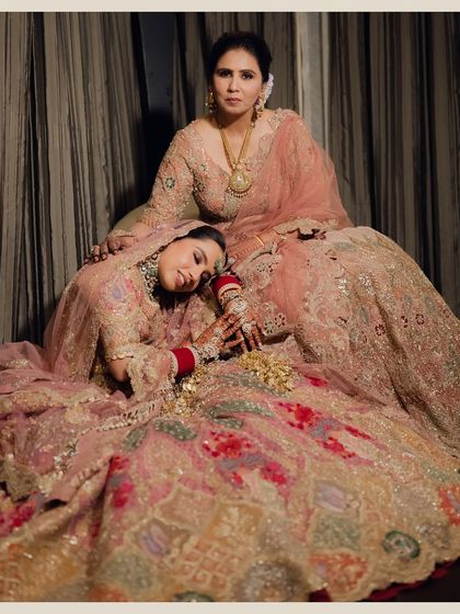 A heartwarming portrait of the bride with her mother. The bride rests her head on her mother's lap, a tender moment capturing the deep bond and emotion of the day.