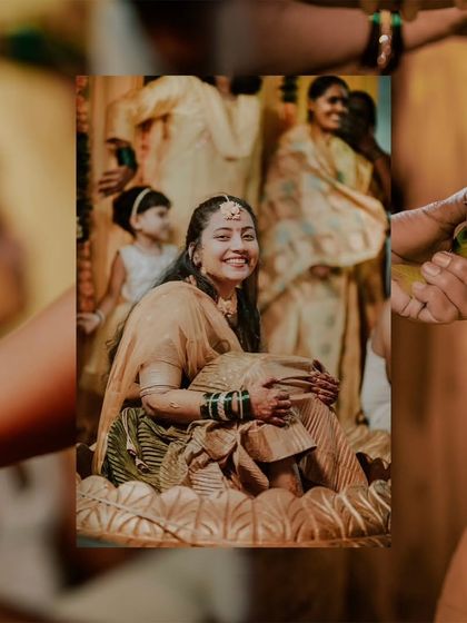 A creative shot of the bride during her Haldi, framed by the hands of her loved ones participating in the ritual.