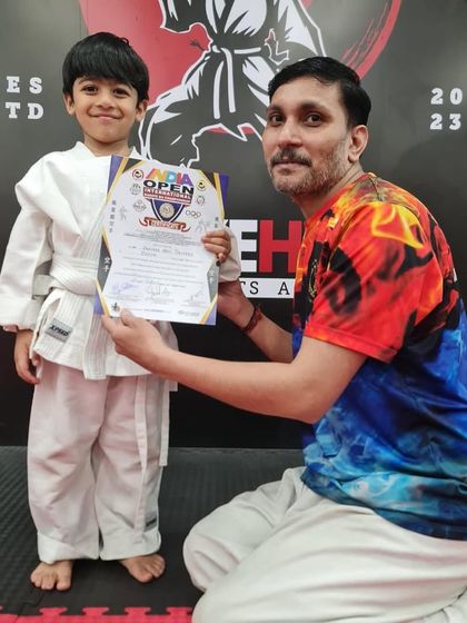 A young champion from our academy proudly holds his certificate at the India Open Karate Championship. We encourage our students to test their skills in competitions.