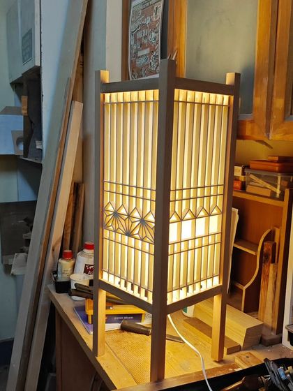 Another angle of a completed student project. The warm light diffuses beautifully through the paper, highlighting the delicate wooden geometry of the Kumiko screen.