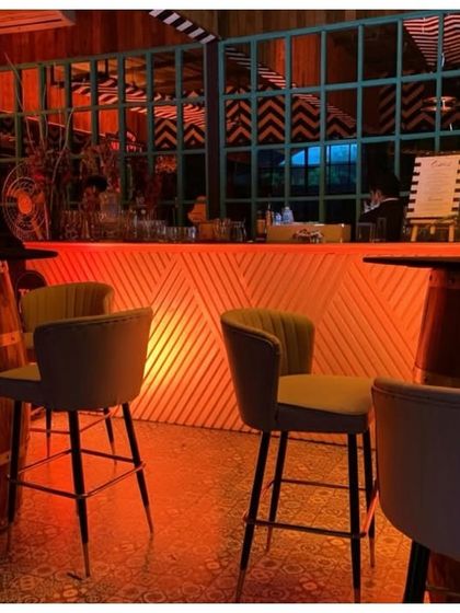 Seating around the bar included rustic barrel high tables and modern chairs. The warm red lighting scheme was carried throughout the space to maintain a cohesive and immersive party vibe.