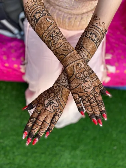 A stunning back-of-hand design with personalized initials. The patterns are a mix of traditional and modern, with bold outlines and delicate fillings.