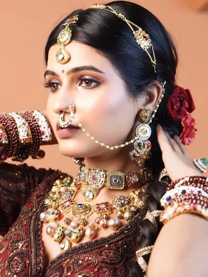 A close-up showcasing the traditional jewellery and the complementary makeup. The bronzed eyes and mauve lips work beautifully with the rich maroon outfit.