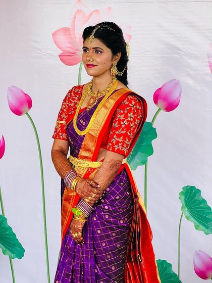 A side profile highlighting the intricate details of the saree, jewelry, and the subtle glow of the makeup. Every element comes together to create a harmonious traditional look.