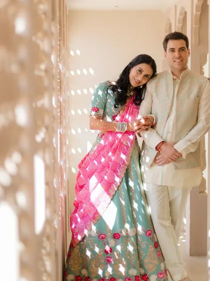 Leaning on him in a sun-dappled corridor. The play of light and shadow adds a layer of warmth and artistry to this candid moment from a Jaipur palace shoot.