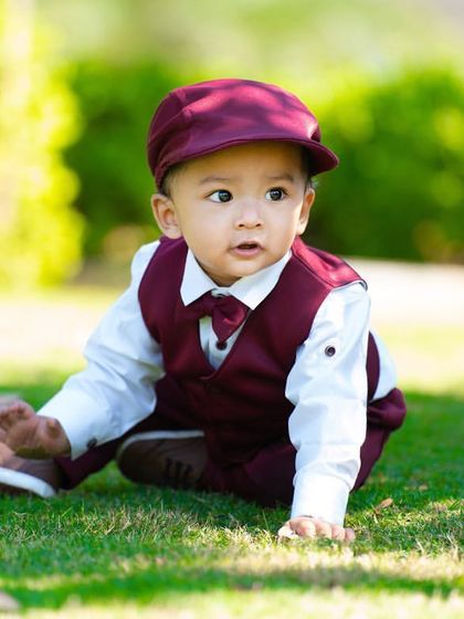This little gentleman is exploring the park during his outdoor first birthday session. The natural light and green grass create a beautiful, timeless portrait.