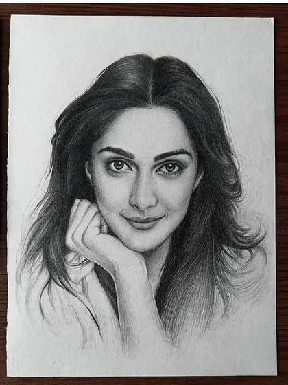 A pencil sketch of actress Kiara Advani, framed by the tools used to create it.