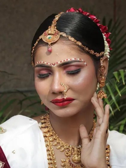This pose highlights the serene expression and the delicate details of the eye makeup and nose ring.