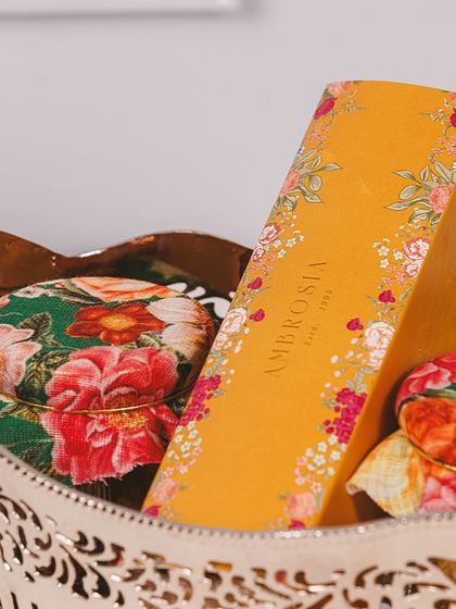 A close-up of our Majestic Basket, showcasing the beautiful floral-wrapped jars and a box of our signature sweets.