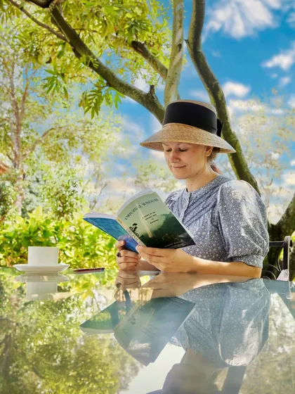 Unwinding after a refreshing Ayurveda treatment. A guest finds a peaceful spot in our garden to read, allowing the therapeutic effects of her session to settle in. This balance of active treatment and quiet rest is key to our programs.