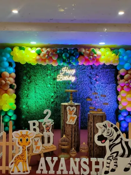 Another angle of the colorful jungle theme, showing the full arrangement with balloon trees and animal cutouts.