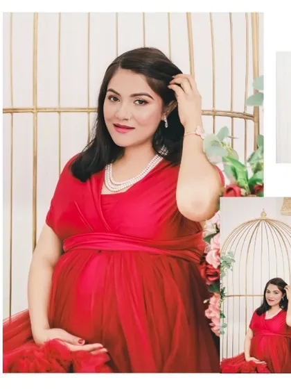 A beautiful seated portrait in a vibrant red gown. The elegant birdcage prop and floral decor add a touch of sophistication to this classic maternity pose.